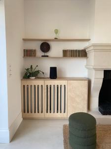 a living room with a wooden radiator and a chair at La Source - Villa wissantaise in Wissant