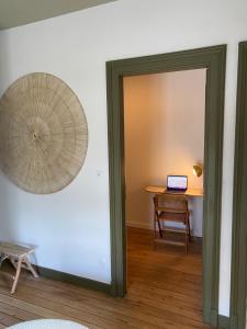 une porte menant à une chambre avec une table et un ordinateur portable dans l'établissement La Source - Villa wissantaise, à Wissant
