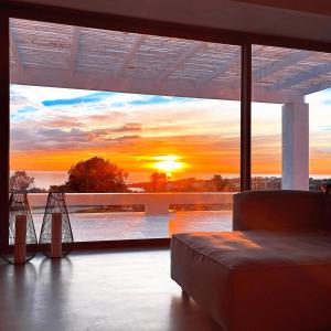 a living room with a view of a sunset through a window at Villa CREA in Marina di Leuca