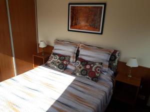 a bed with pillows on it in a bedroom at 4 Ventanales sobre la Avenida Corrientes in Buenos Aires