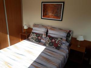 uma cama com almofadas num quarto em 4 Ventanales sobre la Avenida Corrientes em Buenos Aires