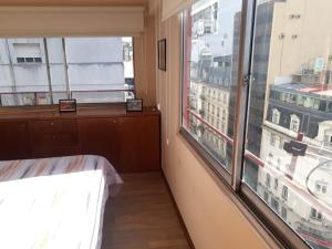 une chambre avec une grande fenêtre avec vue sur une ville dans l'établissement 4 Ventanales sobre la Avenida Corrientes, à Buenos Aires