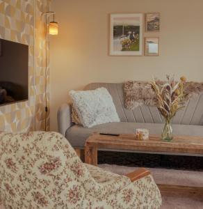 ein Wohnzimmer mit einem Sofa und einem Couchtisch in der Unterkunft Authentic Faroese House / Unique Location / Nature in Hellur