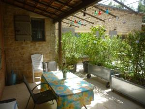 a patio with a table and chairs and plants at PROVENCE SOLEIL LUBERON PISCINE in Apt