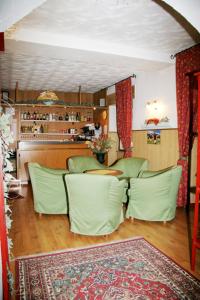 a dining room with green chairs and a table at Albergo Garnì Cavento in Pinzolo