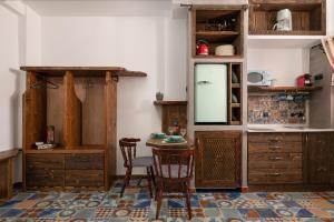 a kitchen with wooden cabinets and a table and chairs at Ey Sofias Suites in Rhodes Town
