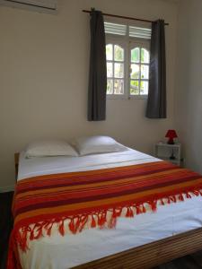 a bedroom with a large bed with a window at Chez Lucile et Gilbert in Bouillante