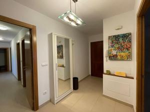 a hallway with a mirror and a painting on the wall at ARZUAWAY in Arzúa