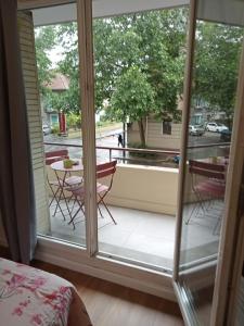 a room with a balcony with a table and chairs at Joli F2 neuf tout équipé proche centre Annecy et Gare in Annecy