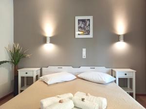 een slaapkamer met een bed met twee handdoeken erop bij Papadioti Apartments in Pefki