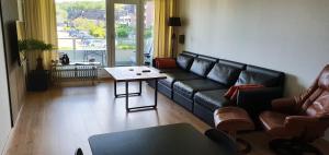 sala de estar con sofá negro y mesa en Am Strand, en Harrislee