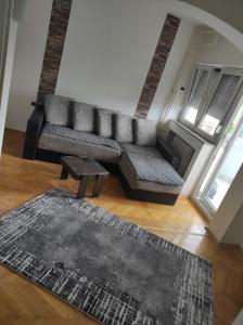 sala de estar con sofá y alfombra en Stan centar, en Bitola