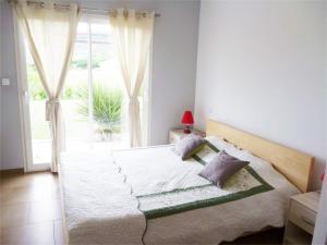 a bedroom with a large bed with a window at villa Soleil 3chambres piscine in Lagorce +19 photos