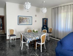 mesa de comedor con sillas y sofá azul en Andrew’s House, en Ortona