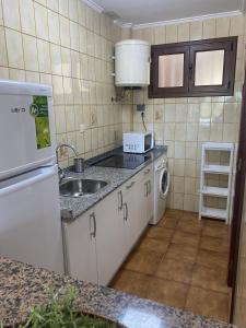 uma pequena cozinha com um lavatório e uma máquina de lavar louça em Noja Ris - 6039 em Noja