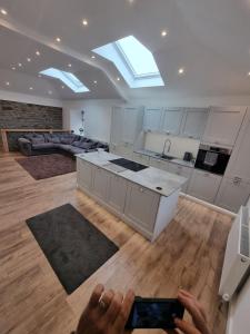 a person holding a cell phone in a kitchen at Beautiful 2 bedroom home with private bar below in Ystradgynlais