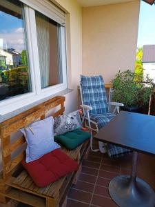a balcony with a table and a bench and a window at Casa del Norte in Brackenheim