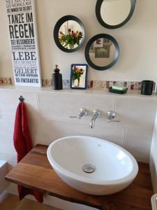 a bathroom with a white sink and some mirrors at Casa del Norte in Brackenheim