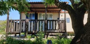 a house with a wooden porch and a tree at The Farm Tiny House - Tiny Casa in Chiclana de la Frontera