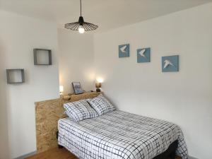a bedroom with a bed with a checkered blanket at Les lumières du phare in Calais