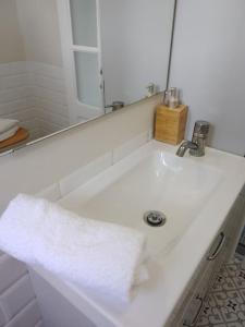 ein Badezimmer mit einem weißen Waschbecken und einem Spiegel in der Unterkunft Apartamento Humboldt ,Island Paradise in La Orotava