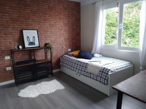 ein Schlafzimmer mit einem Bett und einer Ziegelwand in der Unterkunft Apartamento Humboldt ,Island Paradise in La Orotava