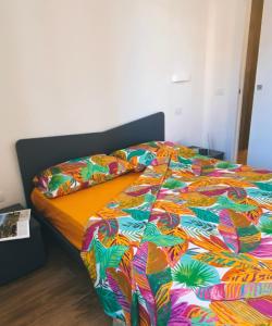 a bed with a colorful comforter in a bedroom at Pineta158 in Cagliari