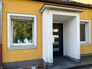 uma casa amarela com uma porta e duas janelas em Apartment HomeBo em Bochum