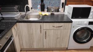 a kitchen with a sink and a washing machine at Burgas Central-Sheynovo in Burgas City