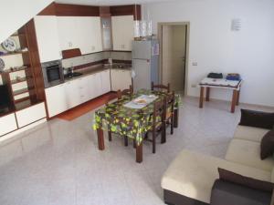 a kitchen and living room with a table and chairs at Angela House in Teulada