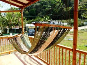 eine Hängematte auf einer Veranda mit einem Zaun in der Unterkunft Domi cabin in Dominical