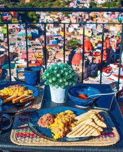 a table with plates of food and a view of a city at Casa Rofo in Guanajuato