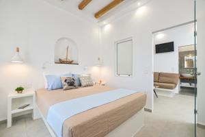 a bedroom with a large bed and a living room at Elite Suites Naxos in Naxos Chora