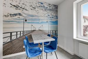 a pier mural in a dining room with a table and blue chairs at Lion Apartments - Rio close to the beach and Monte Cassino in Sopot