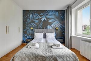 a bedroom with a large bed with a tropical wallpaper at Lion Apartments - Rio close to the beach and Monte Cassino in Sopot