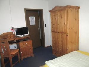 a bedroom with a desk with a computer and a bed at Hotel Haus Frieling in Dortmund +22 photos