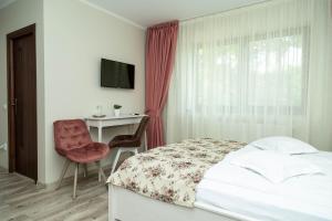 a bedroom with a bed and a chair and a desk at Pensiunea Casablanca in Reghin