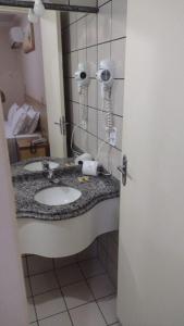 a bathroom with a sink with a blow dryer on the wall at diRoma Fiore Hoteis Caldas Novas e os melhores Parques, Acqua Park, Splash, Slide in Caldas Novas