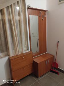- un dressing avec un miroir et une commode en bois dans l'établissement Apartments Jakovljević, à Grebaštica