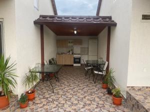 a patio with tables and chairs and a kitchen at Houses by the sea in Vadu
