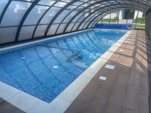 a large swimming pool in a building at Apartament z basenem i ogródkiem Baltic Sun A17 in Sztutowo