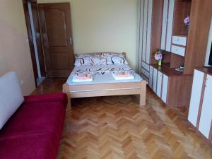 een kleine kamer met een bed en een bank bij Savina in Herceg-Novi