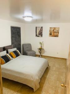 提華納的住宿－El Rincon Amarillo. Zona Dorada.，一间卧室配有一张床和一把椅子