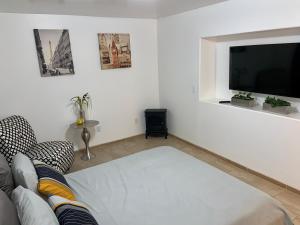 a living room with a couch and a flat screen tv at El Rincon Amarillo. Zona Dorada. in Tijuana