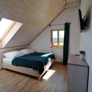 a bedroom with a bed in a attic at Kukułka Mazury in Ruciane-Nida