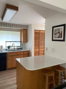 una cocina con encimera blanca y taburetes. en TWO side-by-side dwellings for your giant group, en Corvallis