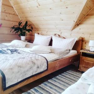 - une chambre avec un lit dans une pièce en bois dans l'établissement Domki i Apartamenty Krupa Ciche, à Zakopane