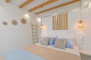 a bedroom with a large bed with blue pillows at Elite Suites Naxos in Naxos Chora