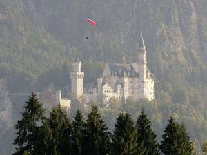 a kite flying over a castle on a mountain at Haus Elise in Füssen
