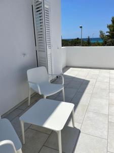 un tavolo bianco e 2 sedie su un patio di ITINERA Baia Verde Rooms and Breakfast a Gallipoli